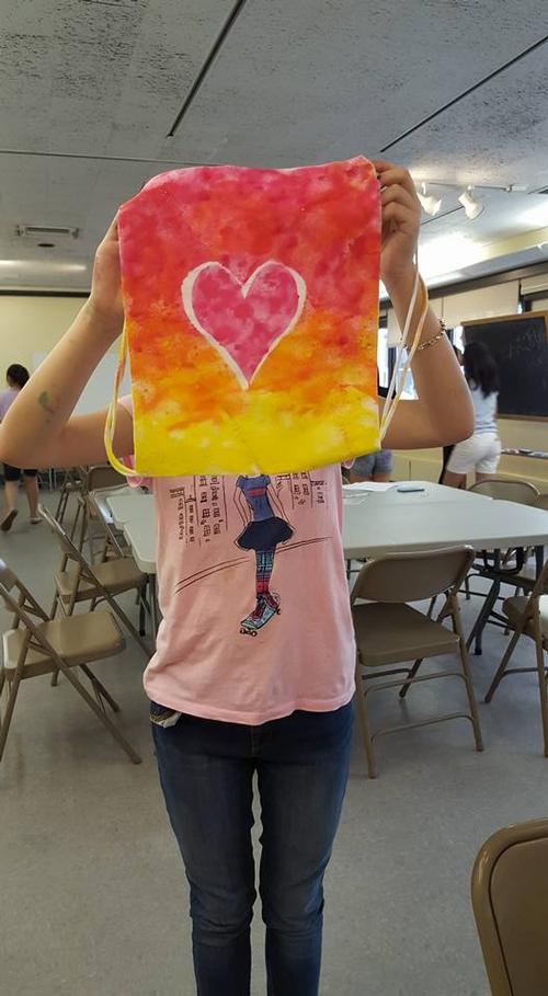 A teen patron holds up a bag she designed at Independence Library.